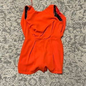 Red orange romper with lace back and cowl back. Zip closure.